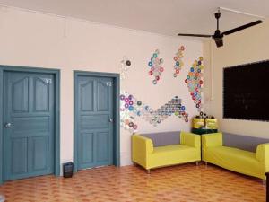 a room with two doors and two chairs and a chalkboard at Beihai forget dust International Youth Hostel in Dianbailiao