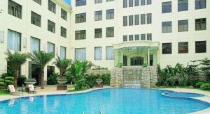a large swimming pool in front of a building at Carrianna Hotel in Foshan