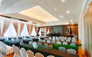 a large lecture hall with white chairs and tables at HW Hotel Padang in Kampungdurian +199 photos