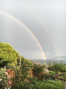 a rainbow in the sky over a garden at B&B La Lanterna in Verbania