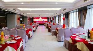 a dining room with tables and chairs with red and white table settings at Liwan International Hotel Chengdu in Chengdu