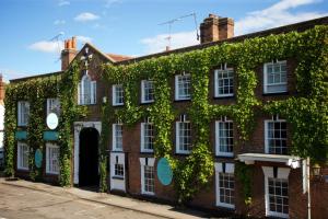 un edificio de ladrillo rojo con hiedra. en The Talbot Inn, en Woking