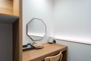 a mirror sitting on top of a wooden counter in a room at H Avenue Hotel Jeonju Terminal in Jeonju