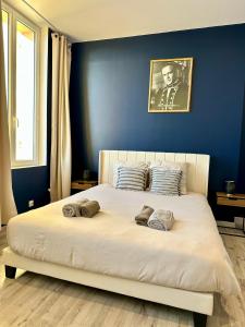 a bedroom with a large bed with a blue wall at Le studio Vintage du centre ville - Proche coeur historique in Bergerac