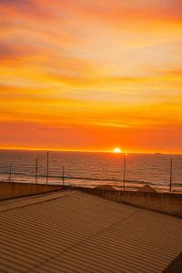 a sunset on the beach with the sun setting over the ocean at Sol Coral in Valdivia