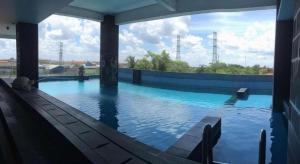 a large swimming pool with blue water in a building at G'Sign Hotel Banjarmasin in Sungai Lutus