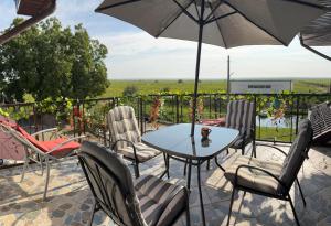 een terras met een tafel, stoelen en een parasol bij Casa Alecu 