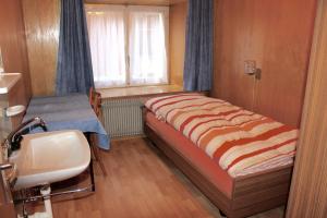 a bedroom with a bed and a sink and a window at Mittaghornblick in Saas-Grund