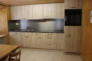 a kitchen with wooden cabinets and a sink and a microwave at Mittaghornblick in Saas-Grund