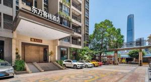 a parking lot with cars parked in front of a building at Oriental Hotel in Dongguan