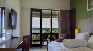 FandoiにあるAsana Biak Papua Hotelのベッドがあり海が見える寝室