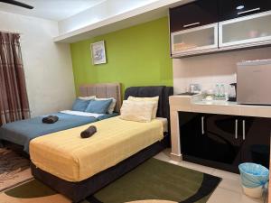 Una pequeña habitación con dos camas y una cocina. en The Viana Apartment 6, en Kota Bharu