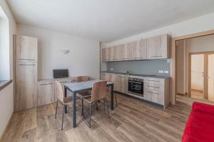 a kitchen with a table and chairs in a room at Casa Scola in Falcade