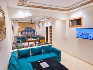 een woonkamer met een blauwe bank en een tv bij Luxury of Mesnana - Stay with low budget in Tanger
