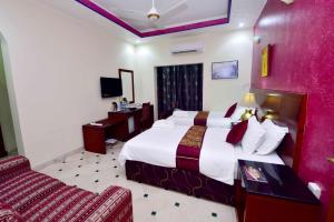 a hotel room with a large bed and a couch at Al Bahjah Hotel in Seeb