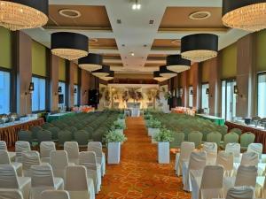 a banquet hall with rows of chairs and a stage at The Oxalis Regency Hotel in Magelang +153 photos