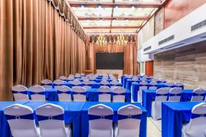 une salle de conférence avec des tables et des chaises bleues et un écran dans l'établissement Moon Crescent Hotel (Chengdu West Steition Culture Palace Metro Stetion Branch), à Supoqiao 90 autres photos