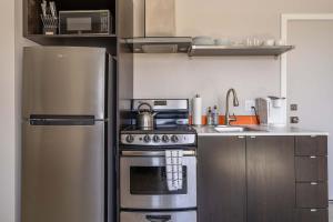 a kitchen with a stainless steel refrigerator and a stove at Stay Portland - Sleek Studio - Food Cart Row & Vintage Shops in Portland