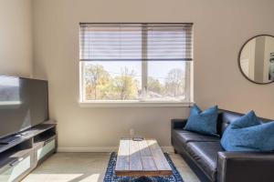 a living room with a black leather couch and a window at Stay Portland - Sleek Studio - Food Cart Row & Vintage Shops in Portland