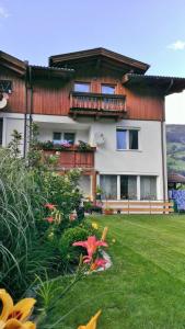 una casa con un jardín con flores delante en Merlin, en Lienz