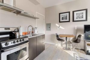 eine Küche mit einem Herd, einer Spüle und einem Tisch in der Unterkunft Stay Portland - Modern Portland Studio - Food Carts & Local Shops in Portland