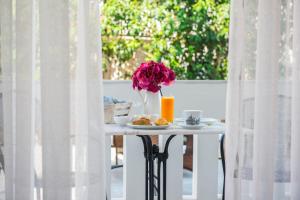 a table topped with a vase filled with flowers at Lefkadio Suites in Lefkada