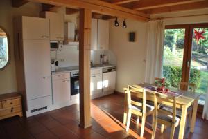 クアオルト・オーバーヴィーゼンタールにあるFerienhaus Keilbergblickのキッチン(白いキャビネット、テーブル付)、ダイニングルーム