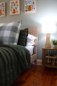 - une chambre avec un lit doté d'une lampe et d'oreillers dans l'établissement Fitzroy Olive Cottage, à Dubbo