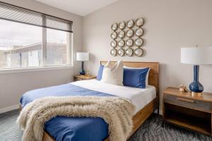 une chambre avec un lit avec des oreillers bleus et une fenêtre dans l'établissement Stay Portland - Retro Modern 2-Bedroom with 90 WalkScore, à Portland