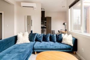 - un canapé bleu dans le salon dans l'établissement Stay Portland - Retro Modern 2-Bedroom with 90 WalkScore, à Portland