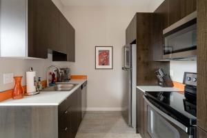 une cuisine avec un évier et un réfrigérateur dans l'établissement Stay Portland - Retro Modern 2-Bedroom with 90 WalkScore, à Portland 27 autres photos