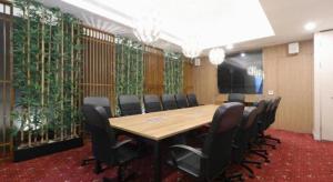 a conference room with a long table and chairs at Hotel Huswah Airport in Jakarta