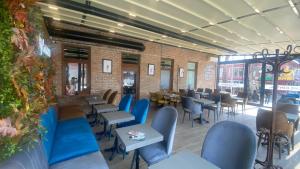 a restaurant with blue chairs and tables and a brick wall at Central Hostel in Sheki