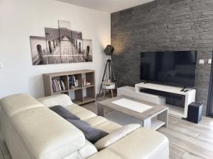 a living room with a couch and a flat screen tv at Entre Bois et Lumiere in Le Brusquet
