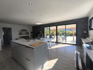 a kitchen with a large white island in a room at Entre Bois et Lumiere in Le Brusquet +10 photos