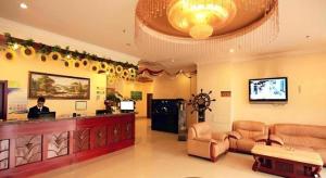 a lobby with a bar and a man sitting at a counter at GreenTree Inn Tianjin Dasi Meijiang Huizhanzhongxin Business Hotel in Tianjin