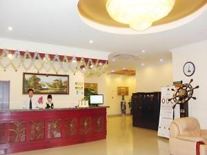 a hotel lobby with a reception desk and a woman at GreenTree Inn Tianjin Dasi Meijiang Huizhanzhongxin Business Hotel in Tianjin