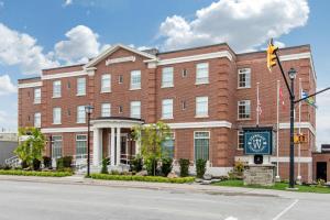 a large brick building with a clock in front of it at The Champlain Waterfront Hotel, an Ascend Collection Hotel in Orillia +27 photos