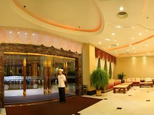 a man standing in front of a hotel lobby at Yijian Holiday Hotel in Zhuhai