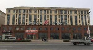 a large building with a sign on top of it at Jinjiang Inn Tianjin Jizhou Renmin West Street Branch in Jizhou