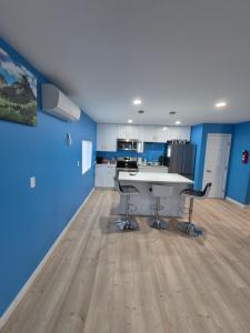 a kitchen with blue walls and a white table and chairs at Work & Lake Guest house at Airport in SeaTac