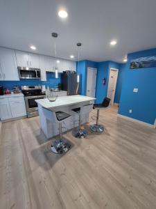 a kitchen with blue walls and a white table and chairs at Work & Lake Guest house at Airport in SeaTac