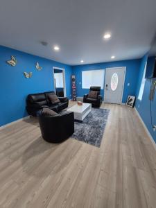 a living room with blue walls and black furniture at Work & Lake Guest house at Airport in SeaTac