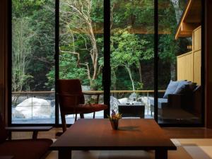 a living room with a table and a large window at Tsukiyominoza in Ise
