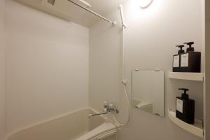 un bagno bianco con lavandino e specchio di Smart VILLA Hatanodai I a Tokyo
