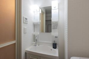 un bagno con lavandino e specchio di Smart VILLA Hatanodai I a Tokyo