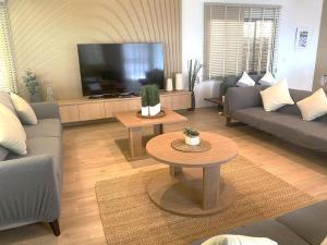 a living room with couches and a tv and a table at B89 3BR Hillside Seaview Escape in Ban Ko Kok