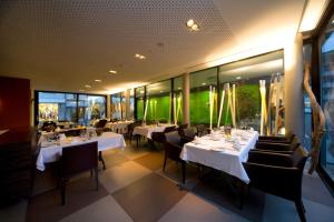 um restaurante com mesas, cadeiras e janelas brancas em Hotel Astoria em Olten