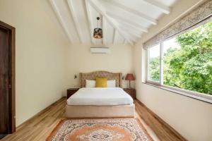 a bedroom with a bed and a large window at Villa Avanora by DanCenter in Arpora