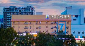 een gebouw met een bord aan de zijkant bij 7 Days Inn Weihai High-Speed Railway & Bus Station in Weihai